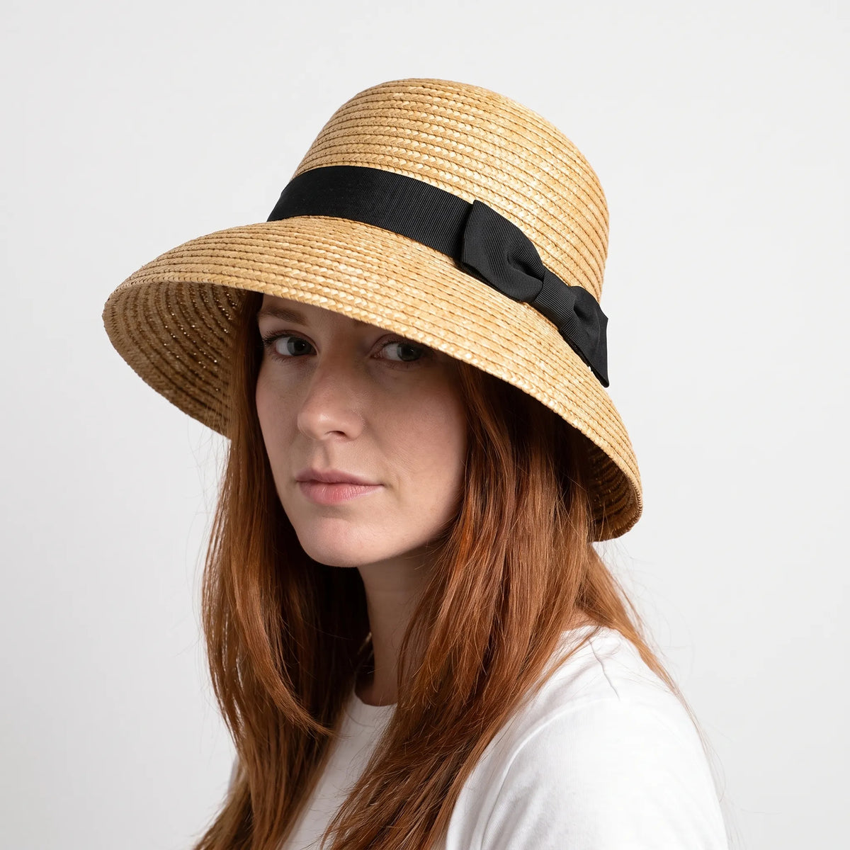Woven cloche hat with wide brim and black ribbon bow detail