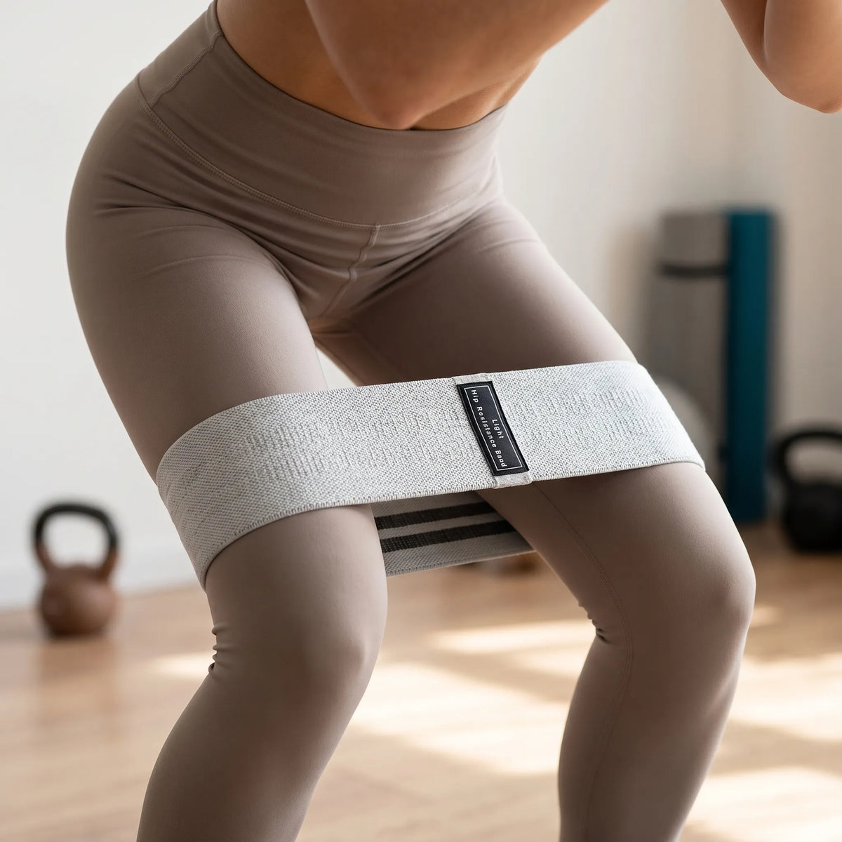 Wide fabric resistance band with labelled tension levels for lower body workouts