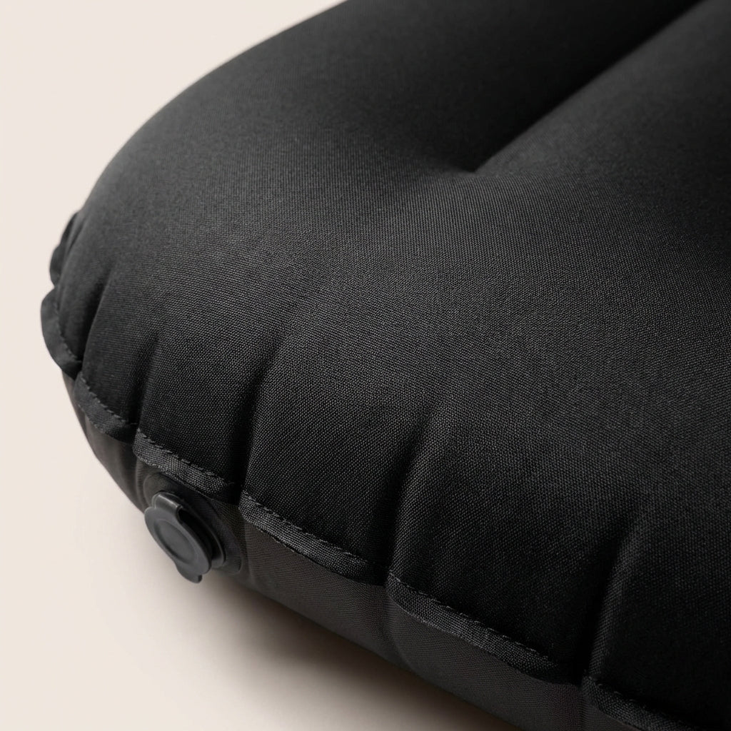 Compact inflatable travel pillow with ergonomic head support and moisture-resistant outer surface