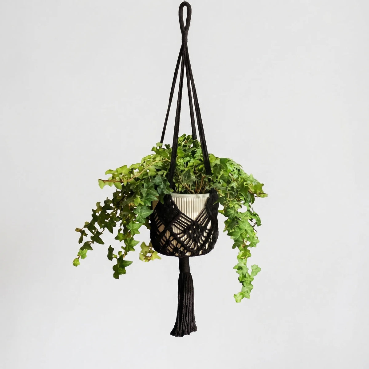 Boho macrame woven plant hanger with geometric knotted design and tassel finish