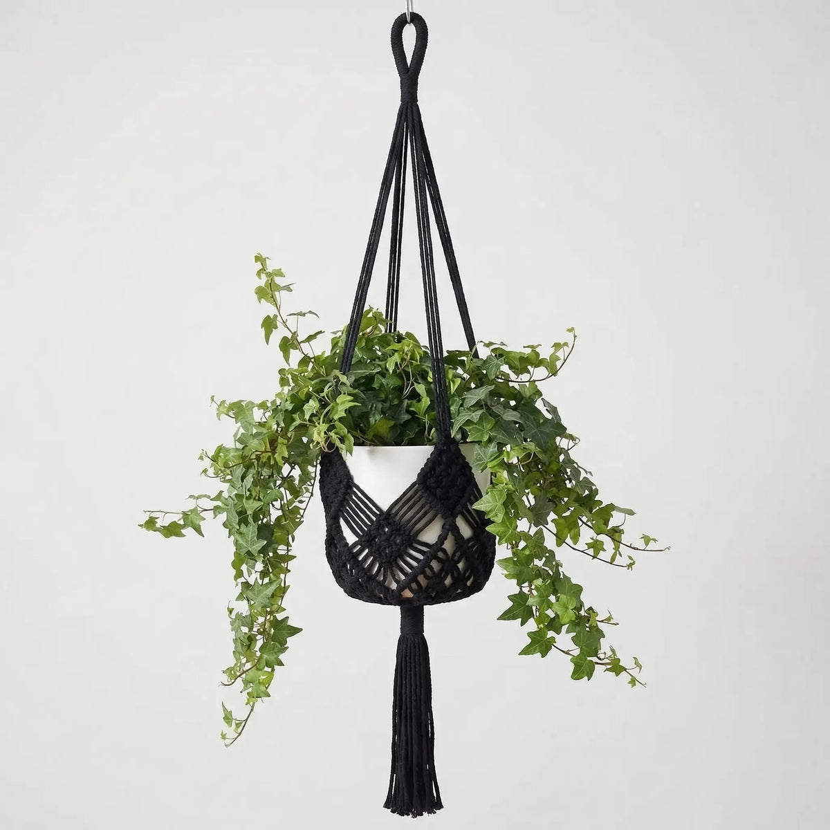 Boho macrame woven plant hanger with geometric knotted design and tassel finish