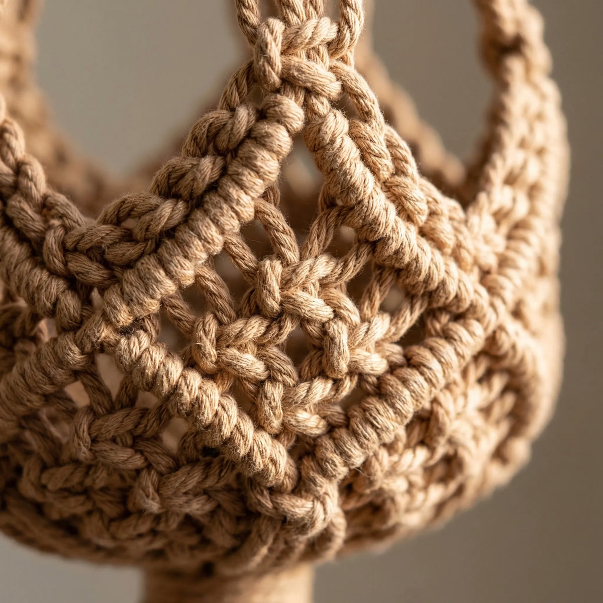Boho macrame woven plant hanger with geometric knotted design and tassel finish