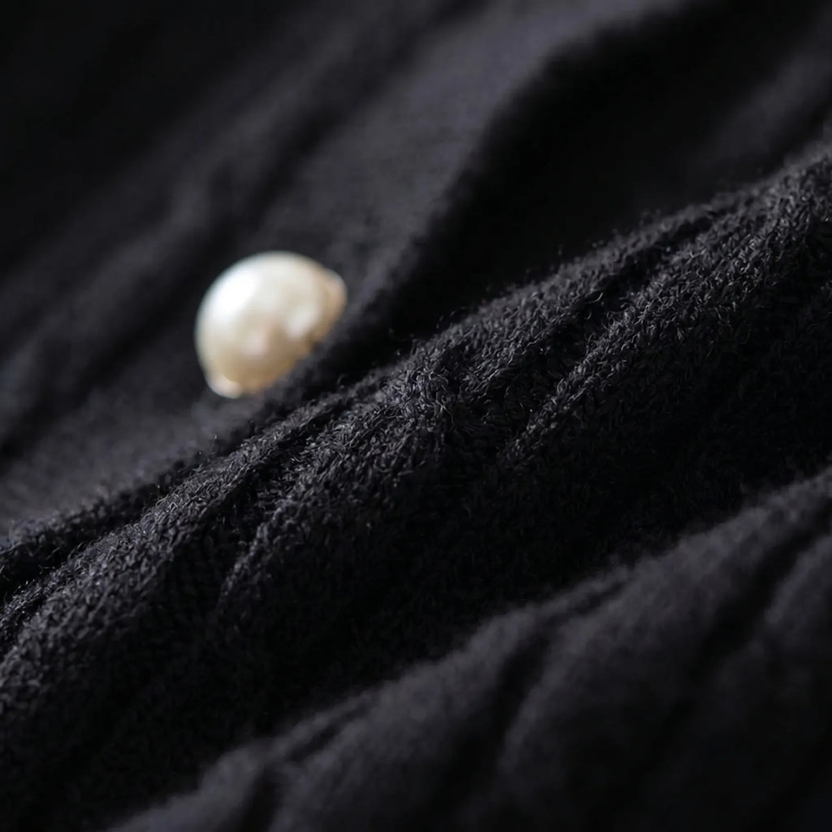 Women's cable knit cardigan with pearl-style buttons and ribbed details