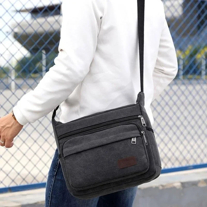 Canvas crossbody messenger bag with adjustable strap and multiple pockets