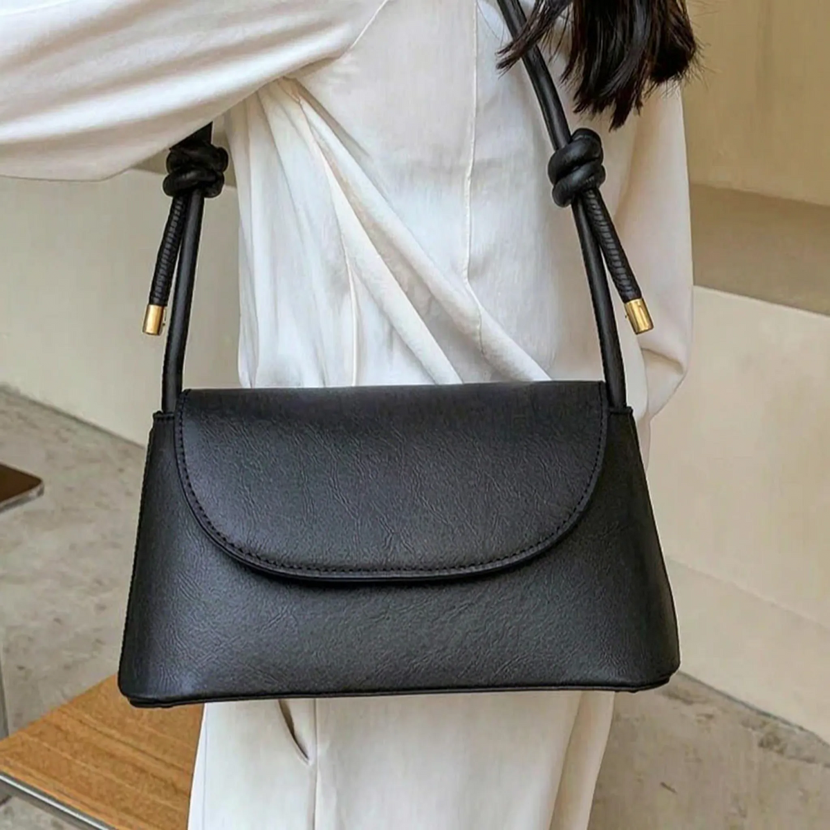 Compact square shoulder bag with knotted strap and flap closure