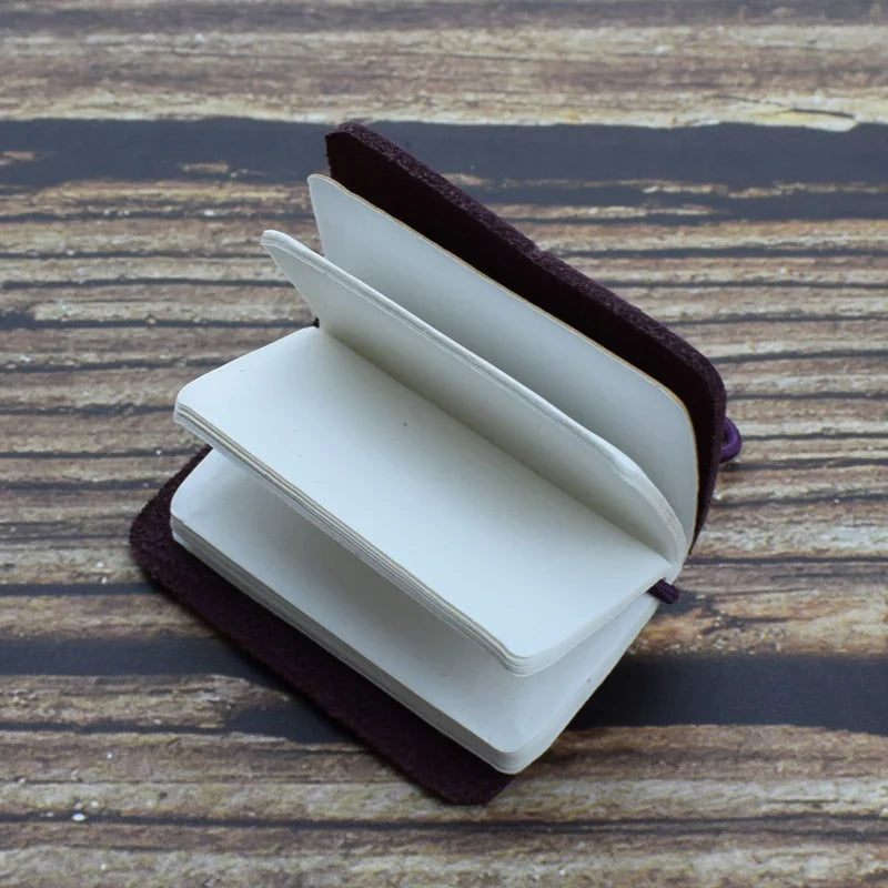 Mini pocket notebook with vintage-inspired design and secure wraparound closure