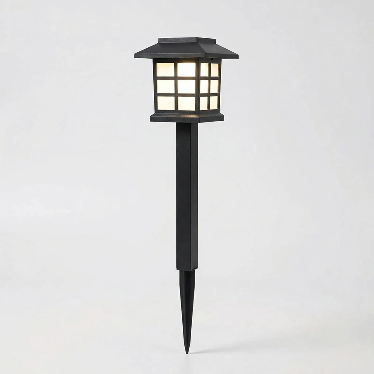 Solar-powered pathway lantern with warm amber glow and pagoda-style design