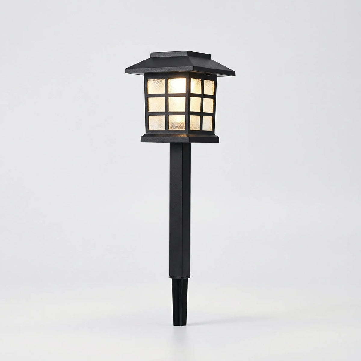 Solar-powered pathway lantern with warm amber glow and pagoda-style design