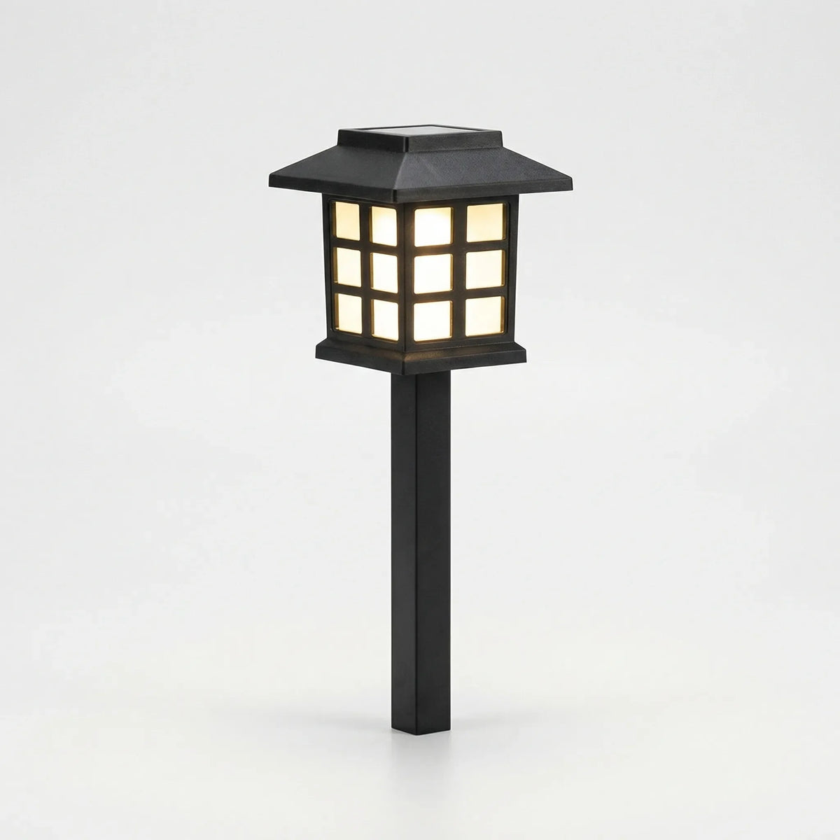 Solar-powered pathway lantern with warm amber glow and pagoda-style design