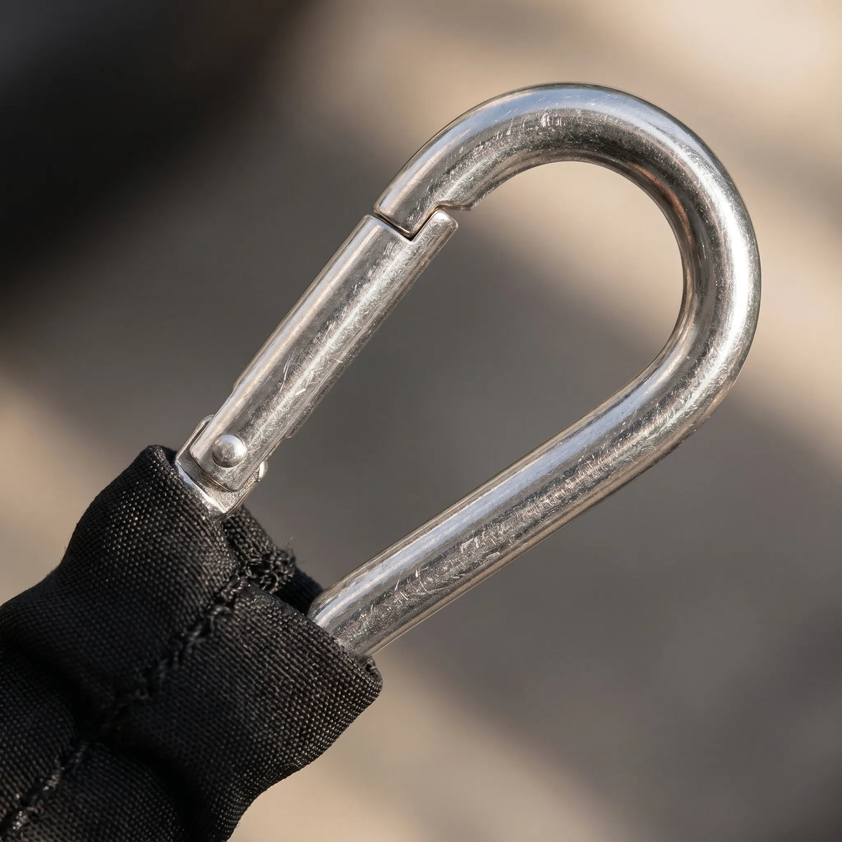 Fabric covered resistance band with metal carabiner clips and progressive tension