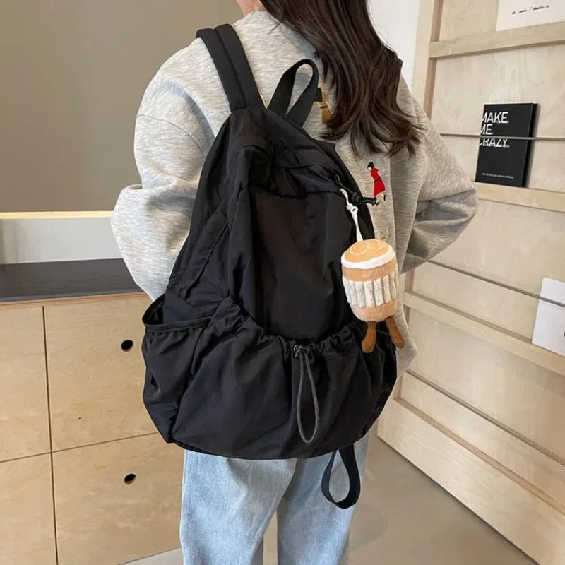 Large-volume nylon backpack with pleated design and padded straps