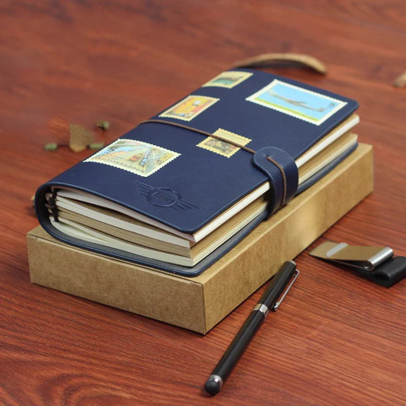Compact A6 travel notebook with strap closure and refillable inserts