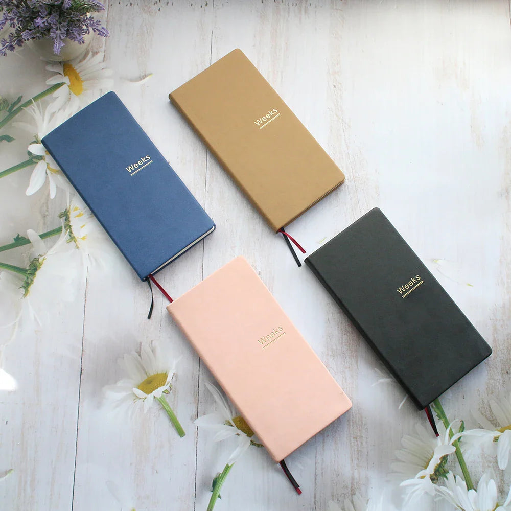 Slim weekly planner notebook with ribbon markers and protective cover